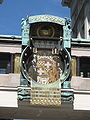 Ankeruhr שעון רחוב מכני חסר מחוגים, בסגנון יוגנדסטיל (בווינה). לוחית השעה, המצוינת בספרות רומיות, נעה לאורך סרגל הדקות. בתמונה מוצג המעבר מהשעה 2:59 ל-3:00.