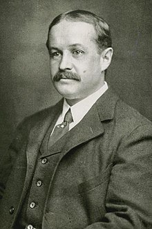 Thayer in middle age; light skin, dark hair, moustache, wearing a business suit