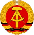 The National emblem of East Germany, a compass, hammer, and circle of rye.