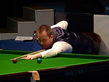 John Higgins playing a shot