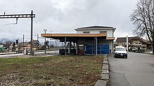 Two-story building with hip roof and canopy-covered wing