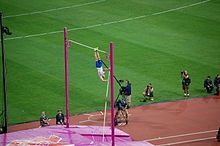 Photographie de Renaud Lavillenie en phase ascendante lors d'un saut à la perche