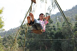 A man swinging in the swing during Dashain festival