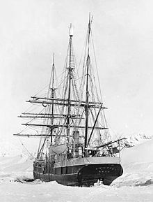 Photographie noir et blanc de l'arrière d'un bateau naviguant à travers la glace.