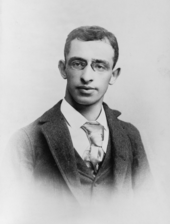 A 22-year-old man wearing an ill-fitting necktie, suit, and vest