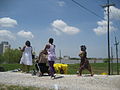 Group of people walking along the levee top eating sno-balls at Algiers RiverFest in New Orleans. Licra pants were still holding out in 2010.