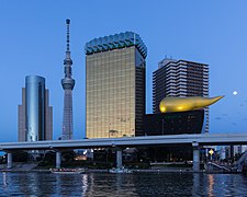 Asahi Breweries headquarters building with the Asahi Flame and Skytree at blue hour with full moon, Sumida-ku, Tokyo, Japan