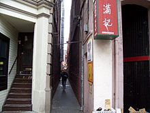 Photograph of an alley with a man walking through it