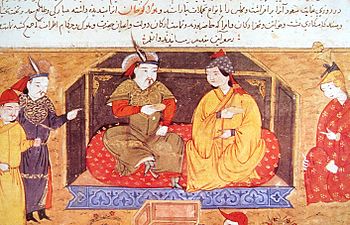 Painting of a man and woman sitting cross-legged on a divan, with three attendants