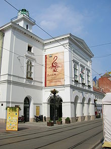 A photo of a large white building with a poster on the side