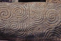 Newgrange – Pietra all'ingresso. Una tripla spirale (triscele), nella metà sinistra dell'immagine.