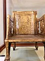 A gilded chair, the back depicts a boating scene