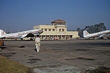 Two planes on the tarmac in front of an airport building