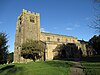 A stone church with a clerestory and a broad battlemented tower