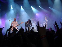 AFI onstage, backlit by blue-and-purple lights