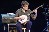 A man sat down playing banjo.