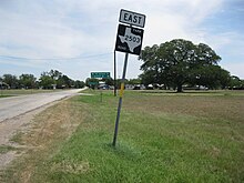 Photo of a sign for Farm to Market Road 2503 with a large oak tree as a backdrop. The photo was taken near the intersection with State Highway 71. View is to the northeast.