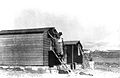 Weatherproofing being fixed to the exterior of first cabins at Harel. 27 October 1948. Bayt Jiz visible in distance.