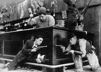 Keaton (left) with Roscoe Arbuckle (top) and Al St. John in still from Out West (1918)