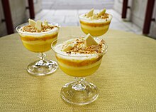 Several glasses containing yellow and white layered trifle