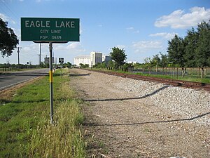 City limit sign has Eagle Lake Rice Dryer in the background.