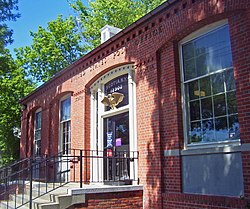 View of front facade of post office from right of front steps, showing Colonial Revival decoration