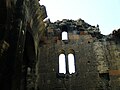 Remains of the vaulted ceiling resting above the southern aisle. Three windows may be also seen at the top of the west wall.