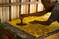 Hand-stamping batik using a cap tool in a Bamako workshop, Mali