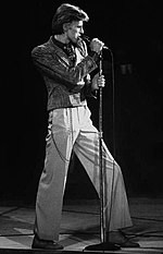 A black and white photo of a man singing into a microphone