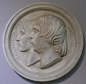 commemorative silver-coloured medallion showing left profiles of Clara and Robert Schumann