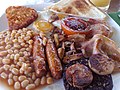 Image 3The full breakfast is among the best known British dishes, consisting of fried egg, sausage, bacon, mushrooms, baked beans, toast, fried tomatoes, and sometimes white or black pudding. (from Culture of the United Kingdom)