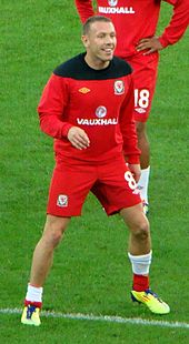 A footballer wearing a red kit