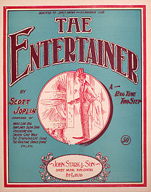 The front cover of "The Entertainer"'s sheet music. It has a green background and in the center is a red ink drawing of a caricatured African-American performer on stage in top hat and tails