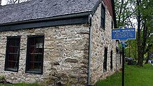 a picture of the marker, with the old stone building behind it