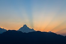 Chaîne de montagnes se découpant à l'horizon dans les rayons du soleil.