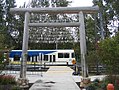 Timber gateway and a waiting train. Facsimiles of historical newspaper headlines are at the base of the wooden poles.