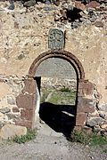 Door to St. Gevorg Church of Geghhovit. The words "St. Gevorg Church" can be read in Armenian to the left and right of the cross on the tympanum.