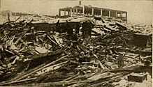 A group of people stand among rubble