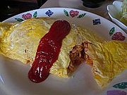 Omurice (omelette au riz japonaise) ouverte, laissant apercevoir sa garniture de riz frit