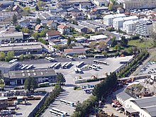 Photographie en couleurs du dépôt de la Sibra avec différents types de véhicules stationnés.