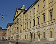 Photographie de la façade d'un bâtiment de couleur ocre.