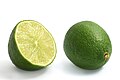 Lime fruits, one cut in half (left) and another intact (right)