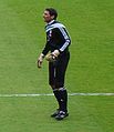 A man wearing a black football kit.