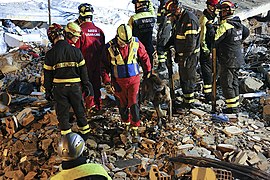 Equipes de busca e resgate da Itália em uma construção desmoronada