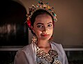 A girl wearing bodo blouse with jewelries; headbands, earrings and necklace