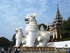 A pair of whitewashed lions[13] guard the entrance to Mandalay Hill