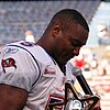 Photo of the side of Derrick Brooks in uniform speaking towards a microphone