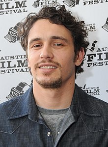 James Franco is smiling towards the camera.