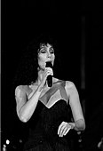 Blac-and-white image of Cher singing onstage.