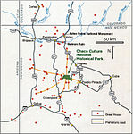 Large square map of northwestern New Mexico and neighboring parts of, clockwise from left, western Arizona, southeastern Utah, and southwestern Colorado. The map region has a green and blocky rectangular-crescent area at its center labeled "Chaco Culture National Historical Park". Radiating from the green region are seven segmented gold lines: "[p]rehistoric roads", each several dozen kilometers in length when measured according to the map scale factor. Roughly seventy red dots mark the location of "Great House[s]"; they are widely spread across the map, many of them far from the green area, near the extremes of the map, more than one hundred kilometers from the green area. Two proceed roughly south, one southwest, one northwest, one straight north, and the last to the southeast. Yellow dots mark the location of modern settlements: "Shiprock", "Cortez", "Farmington", and "Aztec" to the northwest and north; "Nageezi", "Cuba", and "Pueblo Pintado" to the northeast and east; "Grants", "Crownpoint", and "Gallup" to the south and southwest. They are connected by a network of gray lines marking various interstate and state highways. A fan of thin blue lines along the northern margins of the map depict the San Juan River and its communicants.